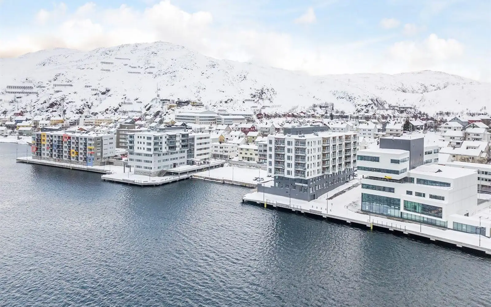 Strandparken i Hammerfest sentrum ved sjøen, med snødekte fjell bak